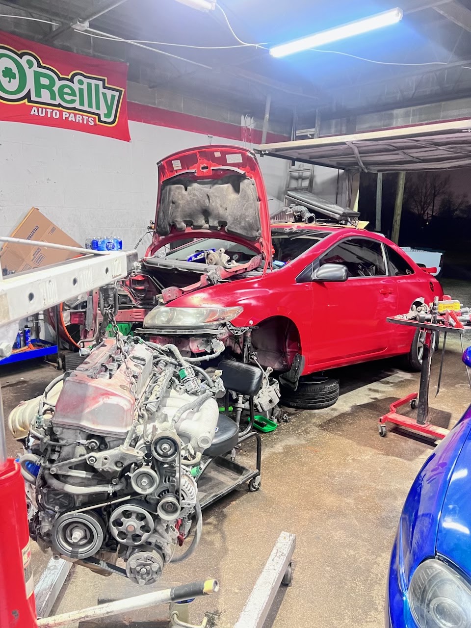 Interior of Castillo Auto Repair showing engines open and tools on the wall